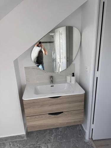 a person taking a picture of a sink in a bathroom at Appartement 3 morangis in Morangis