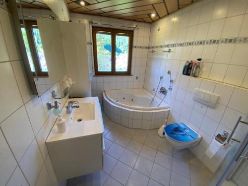 a bathroom with a tub and a toilet and a sink at Gästehaus Brigitte Schoch in Bad Rippoldsau-Schapbach