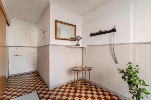 a room with a mirror and a table and a shower at Das weiße Stadthaus in Wesselburen