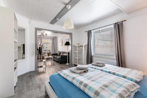 a bedroom with two beds and a living room at Das weiße Stadthaus in Wesselburen