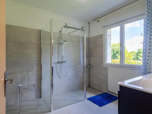 a bathroom with a glass shower with a sink at Maison familiale terrasse et parc in Plouisy