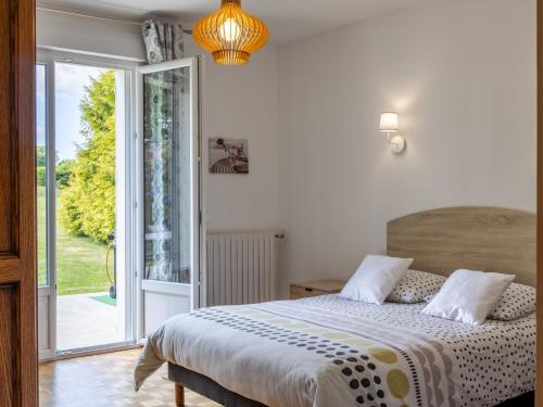 a bedroom with a bed and a sliding glass door at Maison familiale terrasse et parc in Plouisy