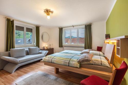 a bedroom with a bed and a couch and a chair at Haus Michler in Todtnau