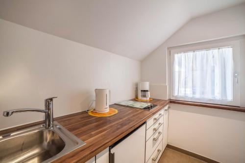a kitchen with a sink and a window at Schnitzer Ferienwohnung Anemone in Rablà