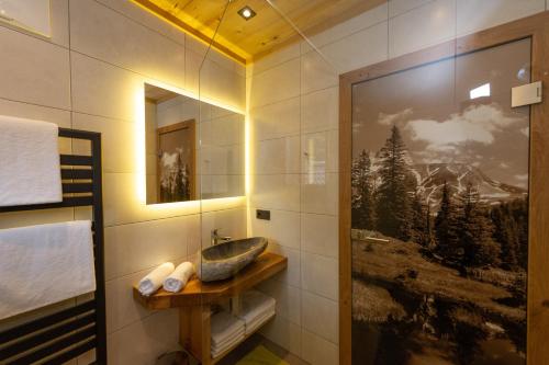 a bathroom with a sink and a picture on the wall at Blockhaus Ganschitter Großarl in Grossarl