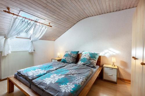 a bedroom with a bed with blue sheets and a window at Ferienwohnung Fly in Wehr