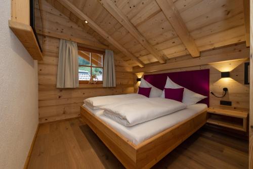 a bedroom with a bed in a log cabin at Blockhaus Ganschitter Großarl in Grossarl