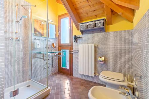 a bathroom with a toilet and a shower and a sink at Lovely Orange House in Viggiù