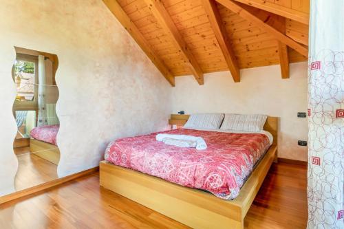 a bedroom with a bed in a room with wooden ceilings at Lovely Orange House in Viggiù