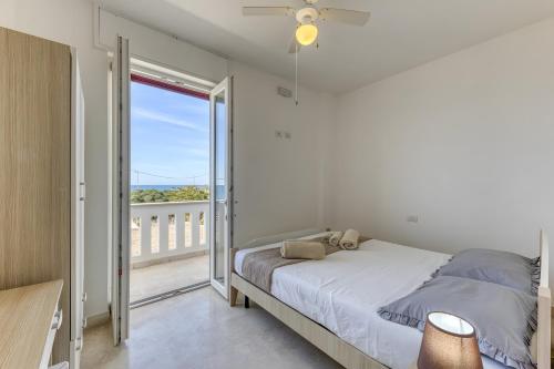 a bedroom with a bed and a balcony at Affittacamere Arcobaleno in Torre San Giovanni Ugento