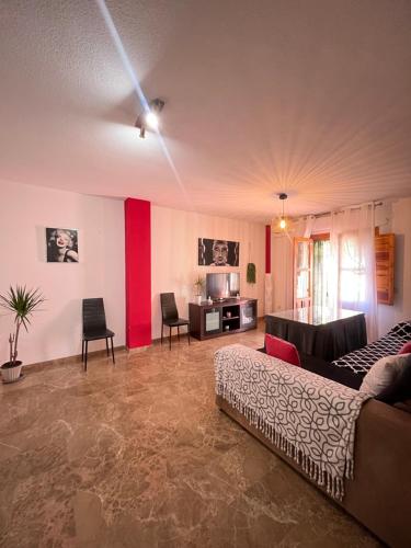 a living room with red and white walls and a couch at La Casa Del Buda in Güéjar-Sierra