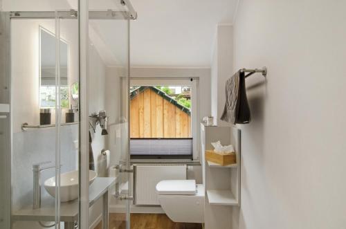 a bathroom with a toilet and a sink and a window at Ferienhaus Berger 2025 in Bad Karlshafen