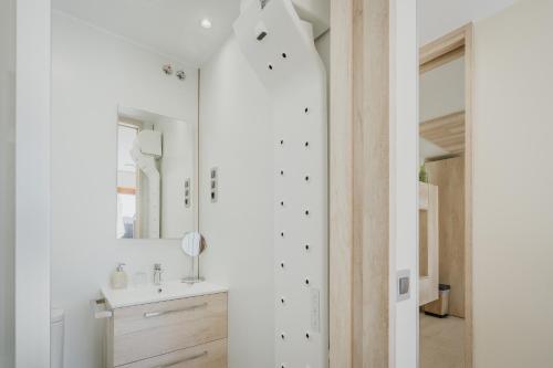 a white bathroom with a sink and a mirror at La Costana De Barbadillo in Barbadillo del Mercado