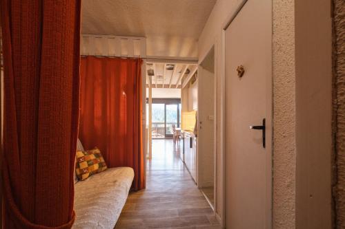 a hallway with a couch and a red curtain at Cosy and nice view on mountains in Villard-de-Lans