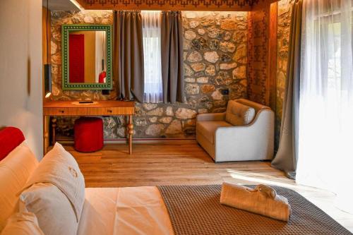 a bedroom with a couch and a chair and a mirror at Golden Villa in Theth