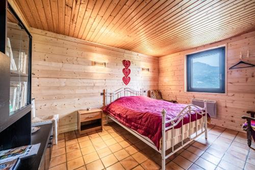 a bedroom with a bed in a log cabin at Chalet la Bartavelle - Morillon in Morillon
