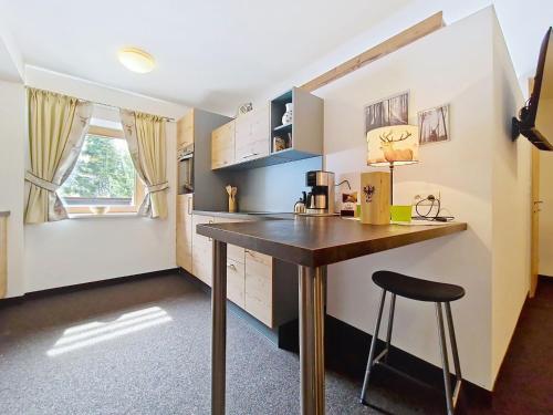 a kitchen with a table and a stool in a room at Apartment Naviser Hütte-2 by Interhome in Navis