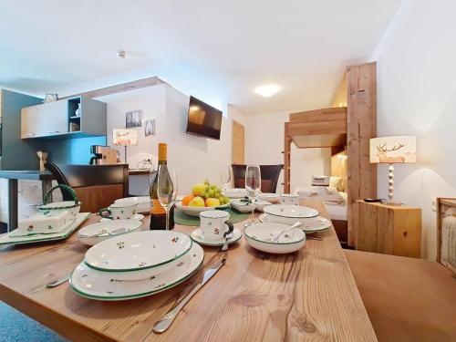 a wooden table with plates and bowls of fruit on it at Apartment Naviser Hütte-2 by Interhome in Navis