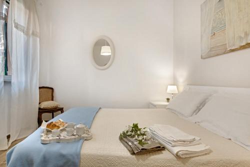 a white bedroom with a bed with towels on it at Un'oasi al Mare in Moneglia