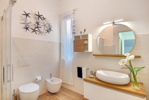 a white bathroom with a sink and a mirror at Un'oasi al Mare in Moneglia