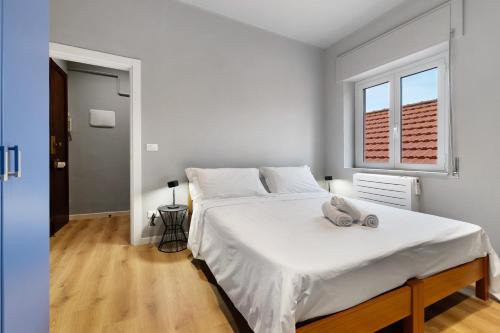 a white bedroom with a large bed with white sheets at Puntodivista in Loano