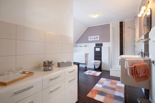 a white bathroom with a sink and a toilet at Ferienwohnung Andresen Högel in Högel