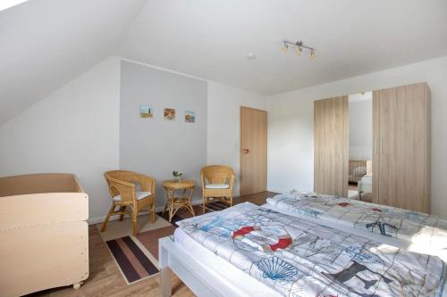a bedroom with a bed and a table and chairs at Ferienwohnung Andresen Högel in Högel