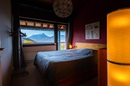 a bedroom with a bed and a large window at Maison avec Piscine, Spa et Jacuzzi in Saint-Jean-dʼArvey