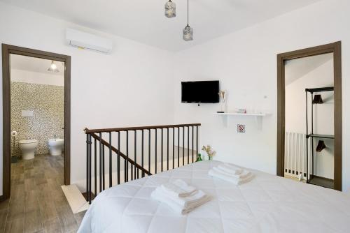 a white bedroom with a bed with towels on it at La Casetta In Canada' in Agerola