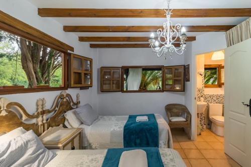 a bedroom with two beds and a chandelier at Kety in Serdió