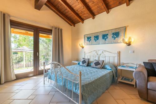 a bedroom with a bed with a blue bedspread at Pretziosa in Castiadas