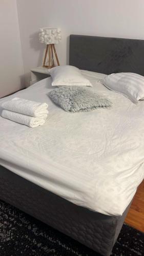 a bed with white sheets and pillows on it at Casa Gla in Râşnov