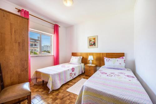 a bedroom with two beds and a window at Villas Brites nº4 in Burgau