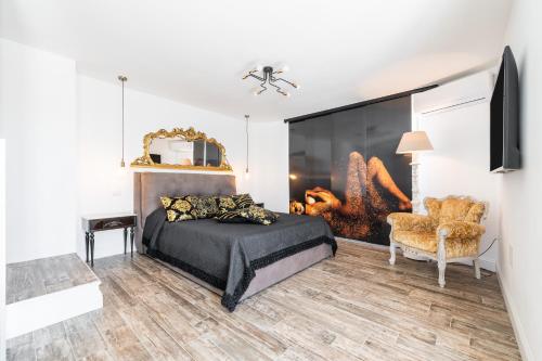a bedroom with a bed and a chair at Villa Leon with Private Pool in Quartu SantʼElena