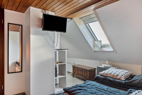 a bedroom with two beds and a tv on the wall at Storchennest in Ludwigsburg