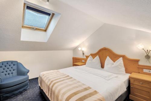 a hotel room with a bed and a blue chair at Loderhof Sand in Taufers in Sand in Taufers
