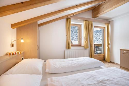 a bedroom with two beds and a window at Runcac Apt Pla in San Vigilio Di Marebbe