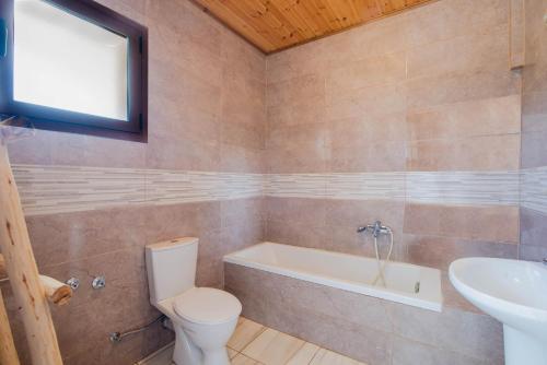 a bathroom with a toilet and a tub and a sink at Mirage Arillas Studio Type B14 in Arillas