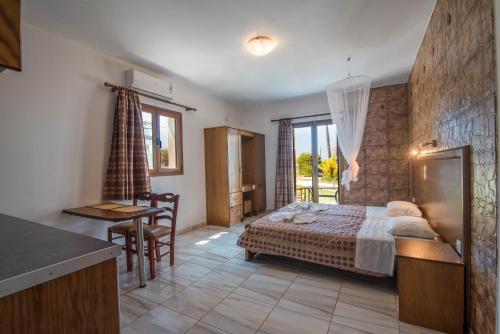 a bedroom with a bed and a table and a kitchen at Mirage Arillas Studio Type B14 in Arillas