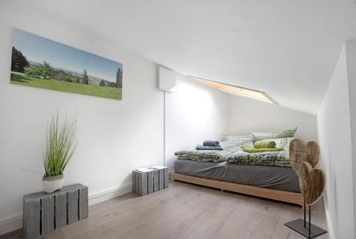 a bedroom with a bed in a white room at Loft mit Seeblick – Allgäu in Petersthal