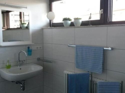 a white bathroom with a sink and a mirror at Ferienwohnung Eppler in Albstadt