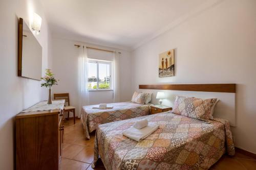 a hotel room with two beds and a window at Casa Bege T1 in Burgau