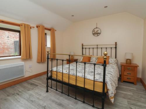 a bedroom with a black bed and a window at Honeybee Cottage in Hull