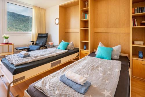 a room with two beds and a chair in it at Ferienwohnung Adrion in Bad Herrenalb