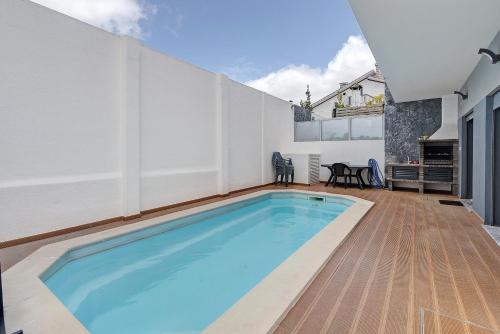 a swimming pool in the backyard of a house at Sunset Holiday Home in Fernao Ferro