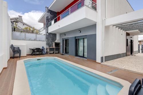 a swimming pool in the backyard of a house at Sunset Holiday Home in Fernao Ferro