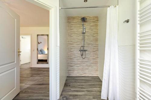 a walkin shower in a bathroom with a brick wall at Amrum in Galmsbüll