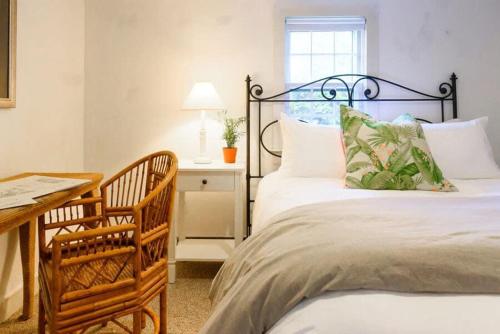 a bedroom with two beds and a table with a lamp at Downtown Historic Nantucket Cottage in Nantucket