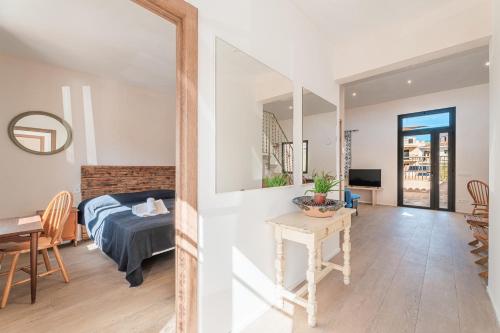 a bedroom and a living room with a bed and a table at Casa La Mar in Santanyi