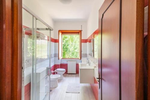 a bathroom with two toilets and a sink and a window at Villa Lucia Guesthouse Minturno in Minturno